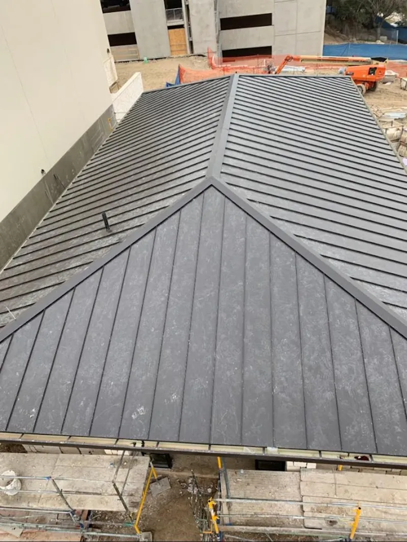 Commercial metal roof construction with crane equipment in Silverton